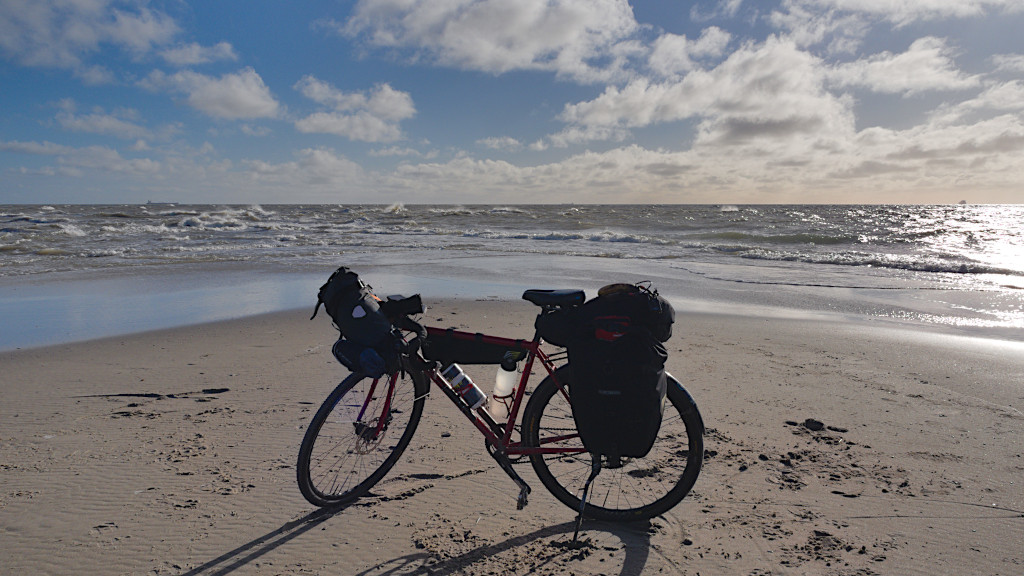 Fahrrad am Strand, dahinter die Nord- und Ostsee