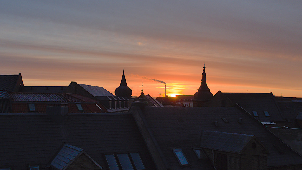 Blick über Aalborgs Dächer zum Sonnenaufgang